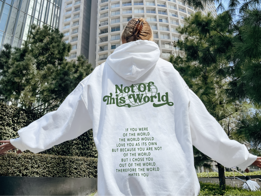 Person wearing a white hoodie with text in an urban setting